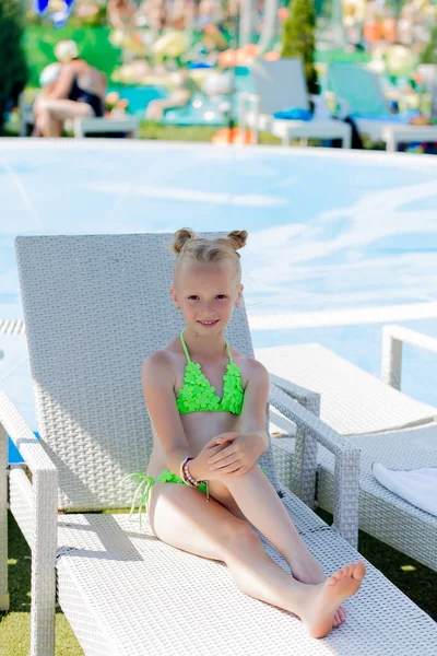 Junges Mädchen im Badeanzug auf einem Regal am Pool — Stockfoto