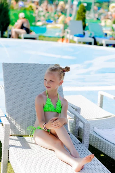 Junges Mädchen im Badeanzug auf einem Regal am Pool — Stockfoto