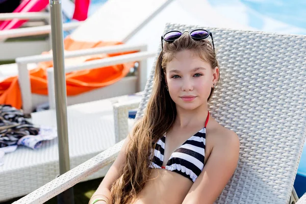 Junges Mädchen im Badeanzug auf einem Regal am Pool — Stockfoto