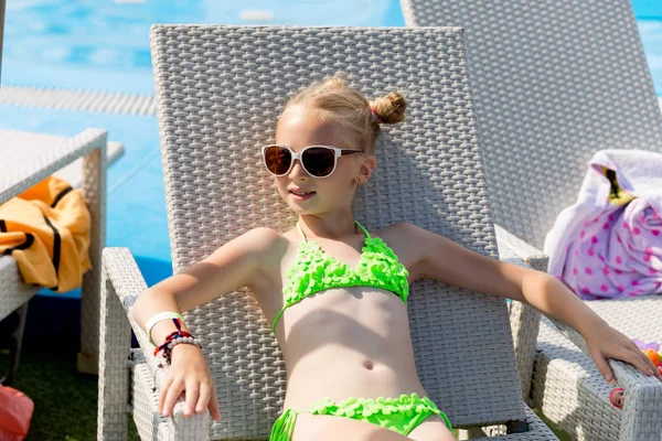 Junges Mädchen im Badeanzug auf einem Regal am Pool — Stockfoto