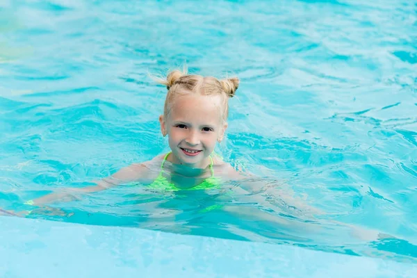 Schönes Mädchen im Badeanzug schwimmt im Pool — Stockfoto