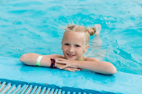 Schönes Mädchen im Badeanzug schwimmt im Pool — Stockfoto