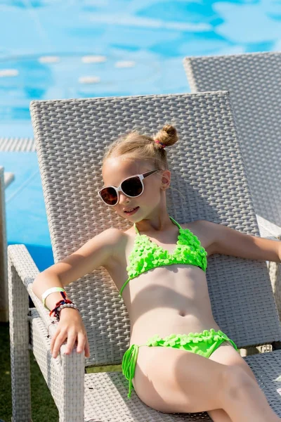 Junges Mädchen im Badeanzug auf einem Regal am Pool — Stockfoto