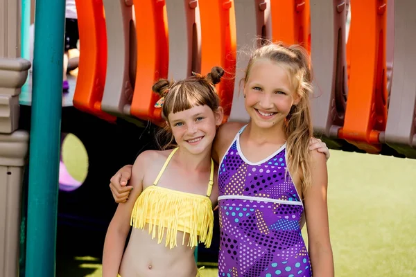 Zwei Mädchen im Badeanzug amüsieren sich auf dem Rasen am Pool — Stockfoto