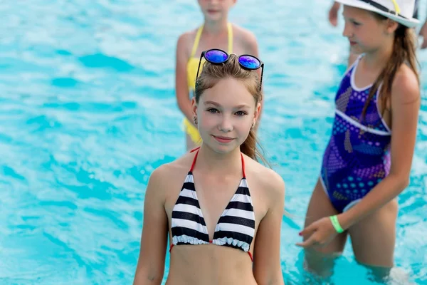 Hermosa chica en un traje de baño nada en la piscina —  Fotos de Stock