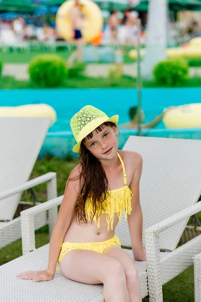 Junges Mädchen im Badeanzug auf einem Regal am Pool — Stockfoto