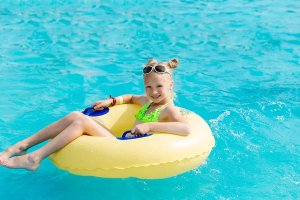 Ein junges Mädchen im Pool auf einem aufblasbaren Schoß — Stockfoto