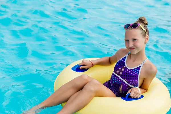 Ein junges Mädchen im Pool auf einem aufblasbaren Schoß — Stockfoto