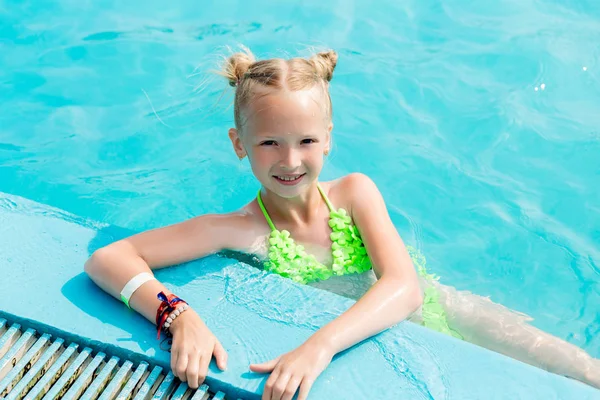 Schönes Mädchen im Badeanzug schwimmt im Pool — Stockfoto