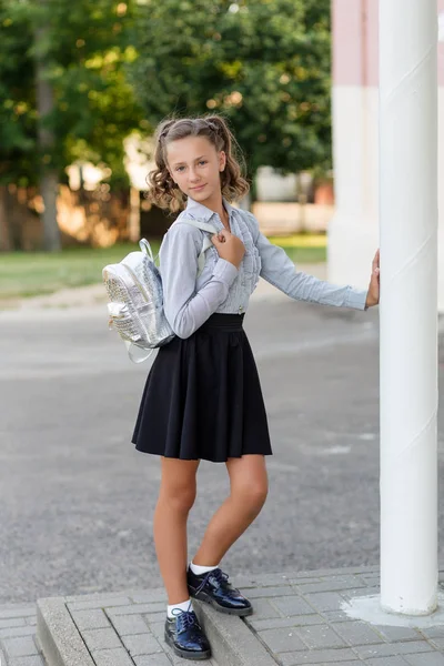 Красива школярка в шкільній формі з рюкзаком на шкурі — стокове фото