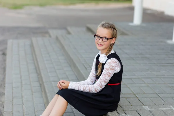 Joven colegiala con gafas y uniforme escolar al aire libre en fro —  Fotos de Stock