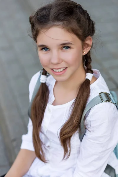 Retrato de uma menina bonita em um uniforme escolar antes da aula em — Fotografia de Stock