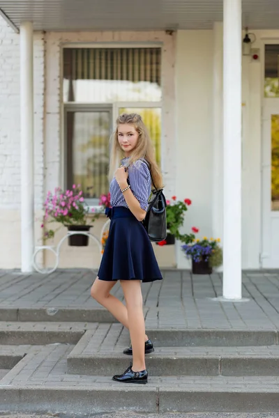 Krásná školačka v školní uniformu s batohem na sc — Stock fotografie