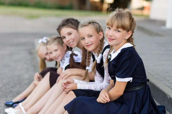 Alunas em uniforme escolar descansam em uma pausa perto da escola — Fotografia de Stock