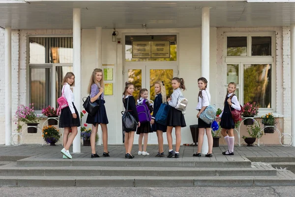 Um grupo de alunas com mochilas vai para a escola — Fotografia de Stock