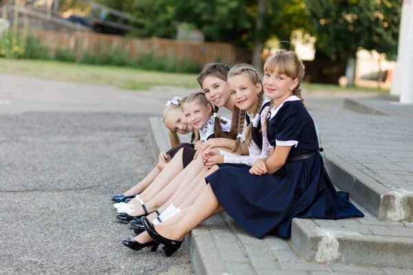 Alunas em uniforme escolar descansam em uma pausa perto da escola — Fotografia de Stock