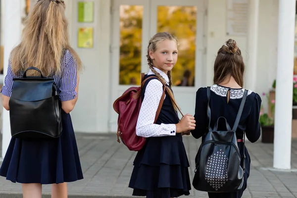 三女孩在学校制服与背包站立在台阶 — 图库照片