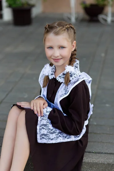 Retrato de uma menina bonita em um uniforme escolar antes da aula em — Fotografia de Stock