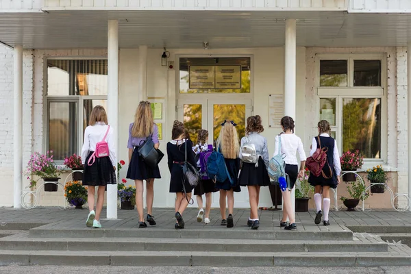 Skupina školačky s batohy jdou do školy — Stock fotografie