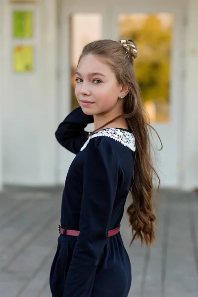 Retrato de uma menina bonita em um uniforme escolar antes da aula em — Fotografia de Stock