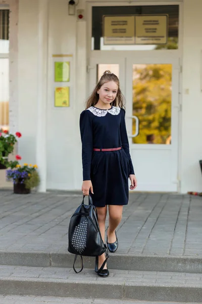 Schöne Schülerin in Schuluniform mit einem Rucksack an der sc — Stockfoto