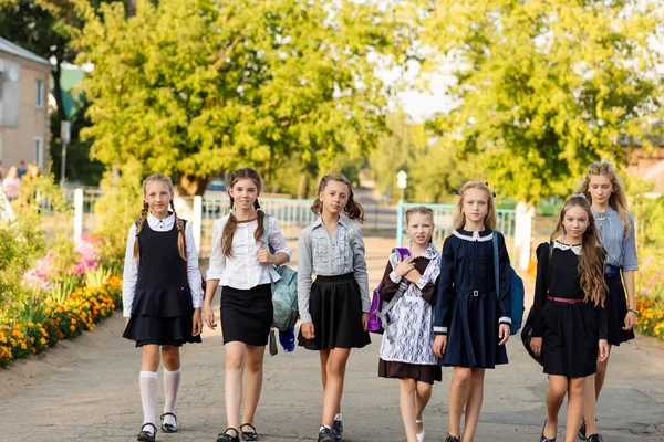 Um grupo de alunas com mochilas vai para a escola — Fotografia de Stock