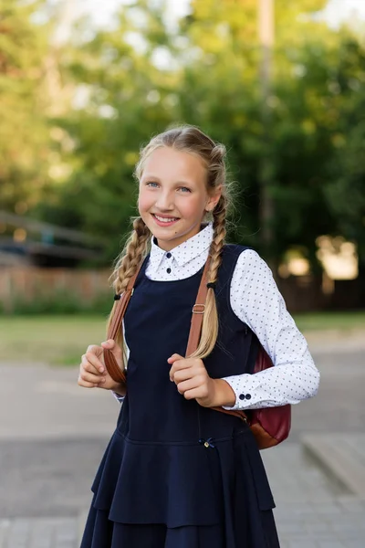 Bela estudante de uniforme escolar com uma mochila no sc — Fotografia de Stock