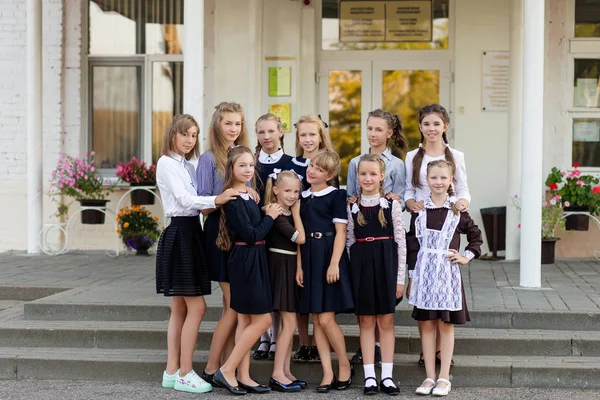 Skupina ve školní uniformě školačky čelí školy — Stock fotografie