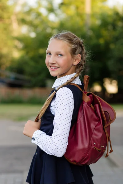 Schöne Schülerin in Schuluniform mit einem Rucksack an der sc — Stockfoto