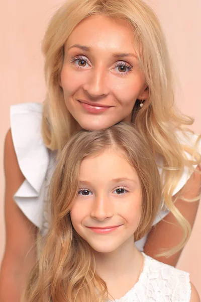 Mom with her daughter in white dresses in the studio. — Stockfoto