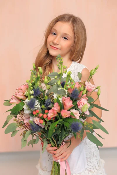 Χαριτωμένο κοριτσάκι με λουλούδια στα χέρια της — Φωτογραφία Αρχείου