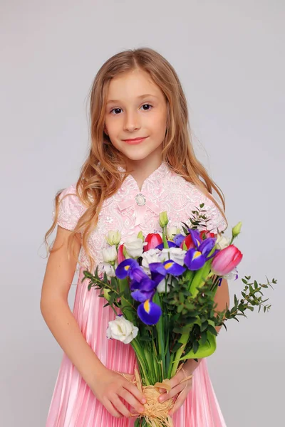 Χαριτωμένο κοριτσάκι με λουλούδια στα χέρια της — Φωτογραφία Αρχείου