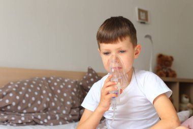 Astım spreyi olan bir çocuk. Çocuk hastalandı.