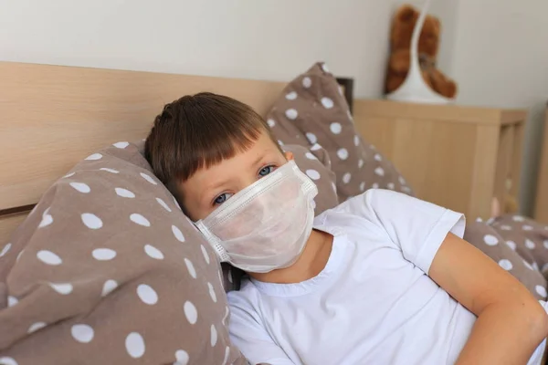 Ένα αγόρι με αναπνευστική μάσκα κάθεται σε καραντίνα στο σπίτι. — Φωτογραφία Αρχείου