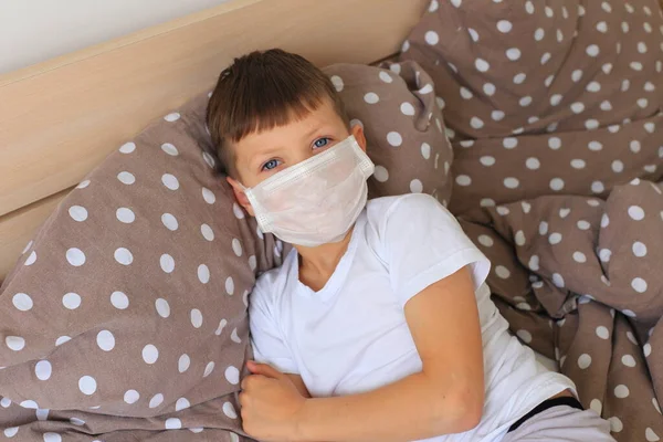 Ένα αγόρι με αναπνευστική μάσκα κάθεται σε καραντίνα στο σπίτι. — Φωτογραφία Αρχείου