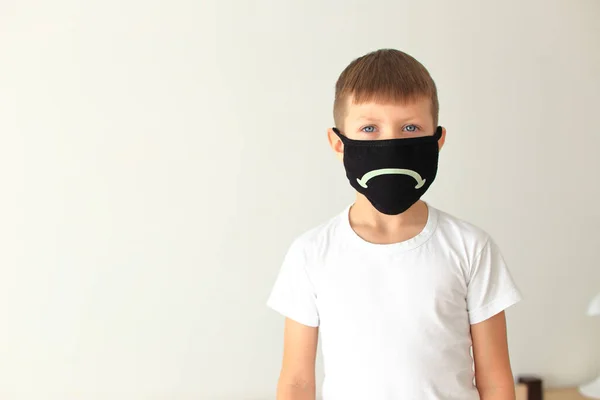 Хлопчик одягає карантинну респіраторну маску вдома — стокове фото