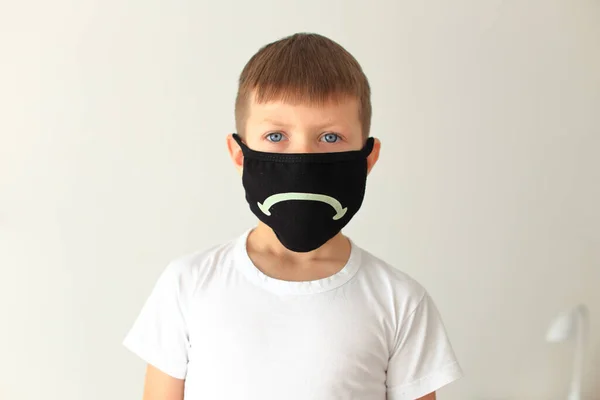 Хлопчик одягає карантинну респіраторну маску вдома — стокове фото