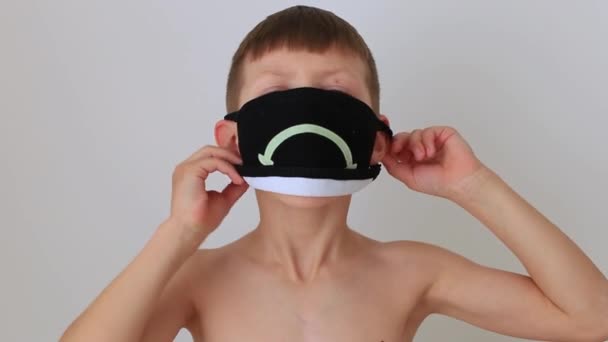 Menino coloca uma máscara respiratória de quarentena em casa — Vídeo de Stock