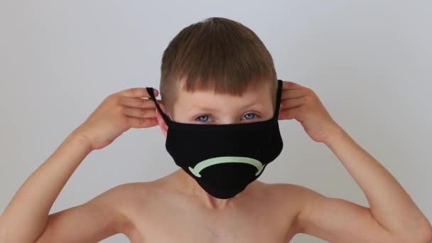 Boy puts on a quarantine respiratory mask at home — Stock Video