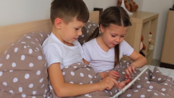 Los niños en una máscara respiratoria se sienta en cuarentena en el juego en casa en tabletas — Vídeo de stock