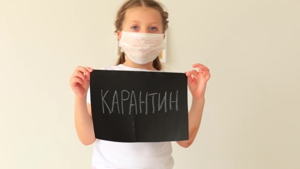 Ragazza in maschera respiratoria si siede in quarantena a casa . — Video Stock