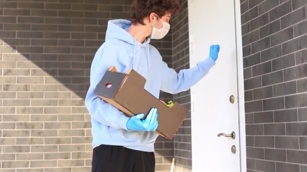 Protective masked courier and glove deliver food to woman — Stock Video