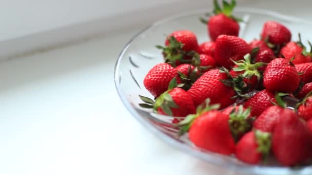 Ein voller Teller mit roten Erdbeeren auf dem Tisch. — Stockvideo