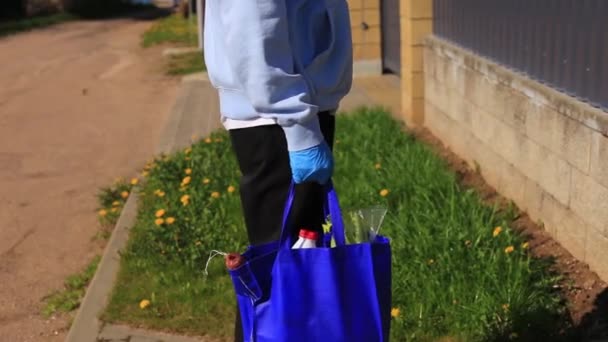 Νεαρός με μια τσάντα με προϊόντα στα χέρια του.. — Αρχείο Βίντεο