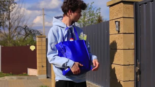 Молодий хлопець з пакетом продуктів в руках . — стокове відео
