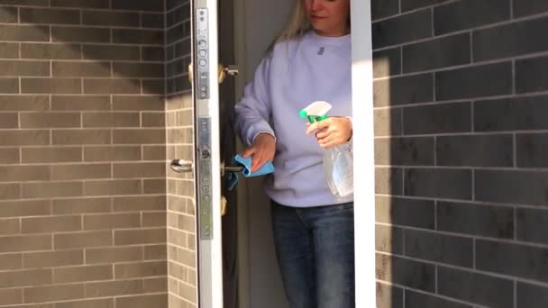 Genç kız kapı kolunu dezenfekte eder. — Stok video
