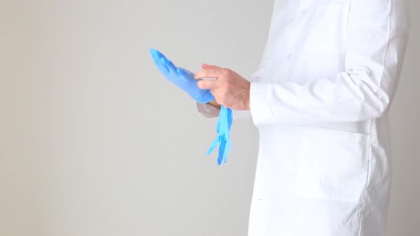 Видео, как врач надевает резиновую перчатку на руку — стоковое видео