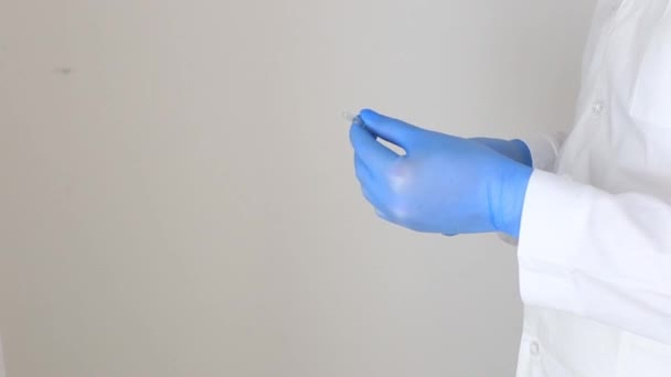 Manos en guantes médicos con una jeringa — Vídeo de stock