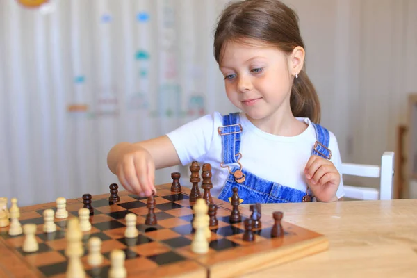 Children at isolation learn remotely a game of chess.