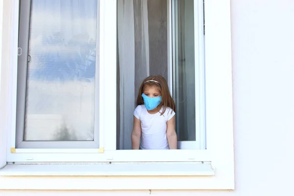 Маленька дівчинка дивиться відкрите вікно на ізоляцію . — стокове фото